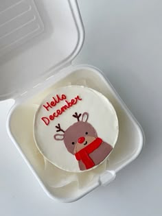 a cake in a plastic container with a reindeer on it