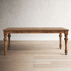 a wooden table sitting on top of a hard wood floor next to a white wall