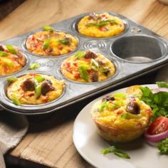 muffins with meat and vegetables are in a muffin tin on a wooden table