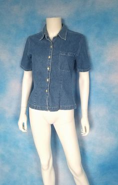 "Cute little fitted minimalist medium-blue denim short sleeved button down top. One breast pocket on the left, tailored for curves. Summertime wardrobe staple! Excellent condition. Decade: 1990s Label: Gap Material: cotton Closure: buttons Vintage Condition: Very Good to Excellent (From a pet and smoke free home) Measurements are taken flat and doubled where necessary. This is marked XS. Neck: 15\" Shoulder span: 15\" Sleeve length: 9\" Cuff: 13\" Bust: 35\" Waist: 30\" Bottom opening: 36\" Leng Blue Denim Shorts, Denim Short, Medium Blue, Workout Shorts, Wardrobe Staples, Womens Clothing Tops, Vintage 90s, Button Downs, Blue Denim