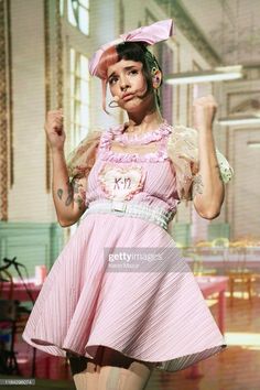 a woman in a pink dress is posing for the camera