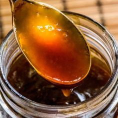 a spoon full of honey on top of a jar