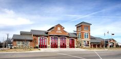 a large red brick building sitting on the side of a road next to a parking lot