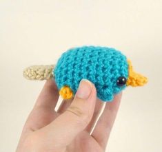 a hand is holding a small crocheted animal