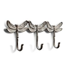 three metal hooks hanging from the side of a wall with two dragon wings on them