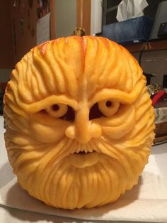 an orange carved to look like a man's face with eyes and beards