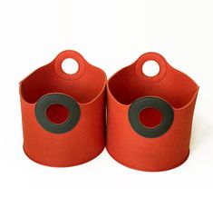 two orange storage bins with black circles on the top and one has a hole in the middle