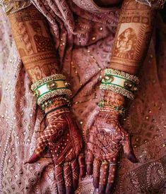 a woman's hands with hennap and bracelets on her arm,