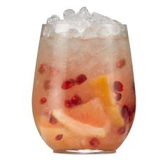 a glass filled with fruit and ice on top of a table