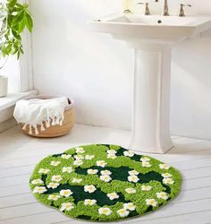 a green rug with white daisies on it in a bathroom next to a sink