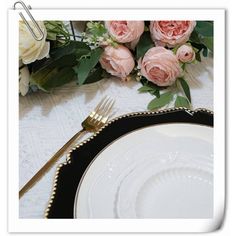 there is a table setting with flowers on it and a fork next to the plate