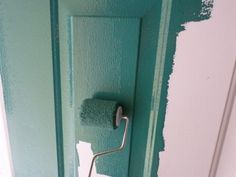 a green painted door with a roll of toilet paper on the handle