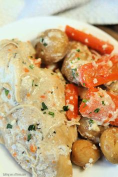 a white plate topped with meat covered in gravy and vegtables