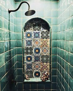 a tiled shower stall with green and blue tiles