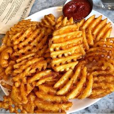 a white plate topped with french fries and ketchup