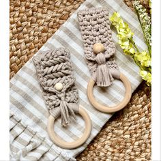 two crocheted objects are sitting on a towel next to some flowers and a green plant