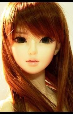 a close up of a doll with long red hair