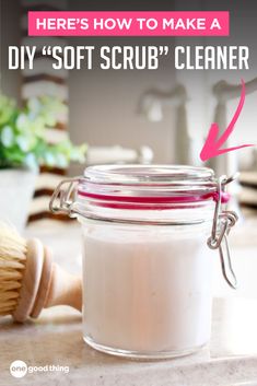 a glass jar filled with white stuff on top of a counter next to a brush