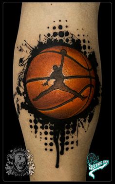 a basketball tattoo on the leg with black ink splatters and an orange ball