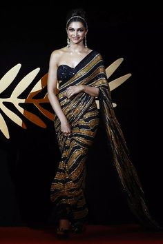 a woman in a black and gold sari