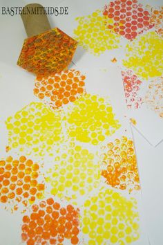 an orange, yellow and red doted paper is on the table next to some papers