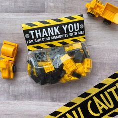 construction themed thank you cards with legos and caution tape on the table next to them