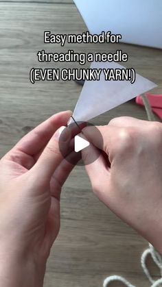 someone is cutting paper with scissors on a wooden table and the words easy method for threading a needle even chunky yarn