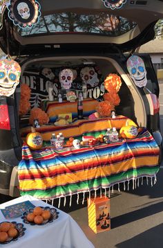 a trunk full of food and decorations for a day of the dead party in a car