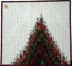 a quilted christmas tree with red and green decorations on it's side, in front of a white background