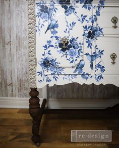 a blue and white cabinet with flowers painted on it