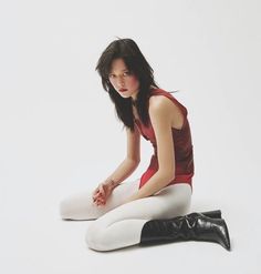 a woman is sitting on the floor with her legs crossed and wearing white tights