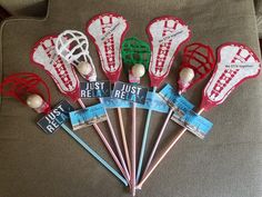 six red and white lacrosse racquets sitting on top of a couch