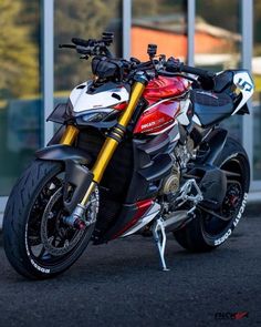 a red and white motorcycle parked in front of a building