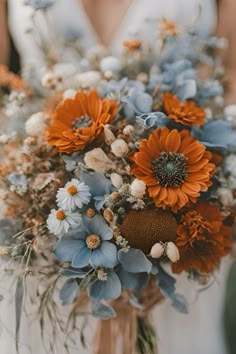 Dusty blue and burnt orange wedding bouquet    Dusty blue burnt orange wedding | dusty blue wedding | burnt orange wedding | rust orange wedding | dusty blue burnt orange wedding theme | dusty blue burnt orange wedding flowers | dusty blue burnt orange wedding ideas | wedding bouquet | fall wedding bouquet | fall wedding bouquet ideas Powder Blue And Orange Wedding, Dusty Blue And Rust Wedding Flowers, White Orange Blue Wedding Bouquet, Dusty Blue And Copper Wedding Theme, Steel Blue Fall Wedding, Teal And Orange Flowers, Burnt Orange Navy Blue Color Palette, Fall Bouquet With Blue, Dark Teal Orange Wedding