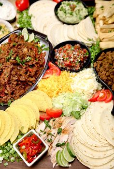 an assortment of mexican food is displayed on a table