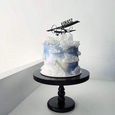 there is a cake that has been decorated with clouds and an airplane on the top