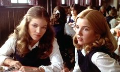 two women sitting at a table with food in front of them