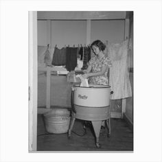 an old photo of a woman ironing clothes in her laundry room by corbi