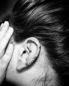 a woman with her hand on her ear has a skeleton painted on it's side