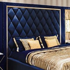 a bedroom with a blue headboard and gold pillows