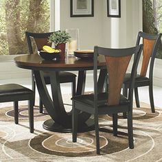 a dining room table with four chairs and a bowl of fruit on the top of it