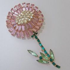 a pink flower brooch sitting on top of a table