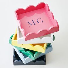 a stack of colorful paper plates with the letter m g written on one side and an empty plate in the other