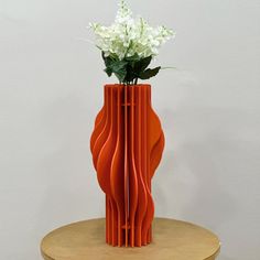 an orange vase with white flowers in it