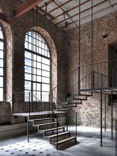 an old brick building with several windows and stairs leading up to the second floor area