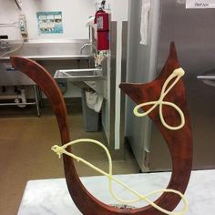 a wooden sculpture sitting on top of a white marble counter next to a metal sink