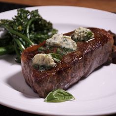 a steak and broccoli on a white plate