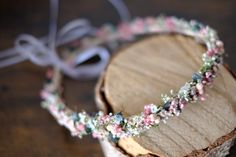 a close up of a piece of wood with a flower crown on top of it