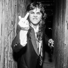 black and white photograph of woman in suit holding up peace sign