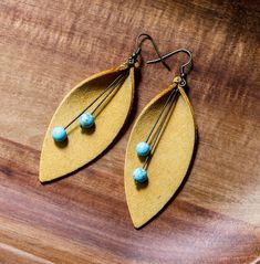 Add a pop of color with these lightweight statement suede leather earrings featuring a curved leaf shape in yellow with turquoise accents. Additional colors available upon request. Nickel-free hardware. 3 drop. See a similar style and additional colors here: https://etsy.me/2P9SJww Leather Leaf Earrings, Leather Leaf, Leather Diy Crafts, Turquoise Accents, Boho Leather